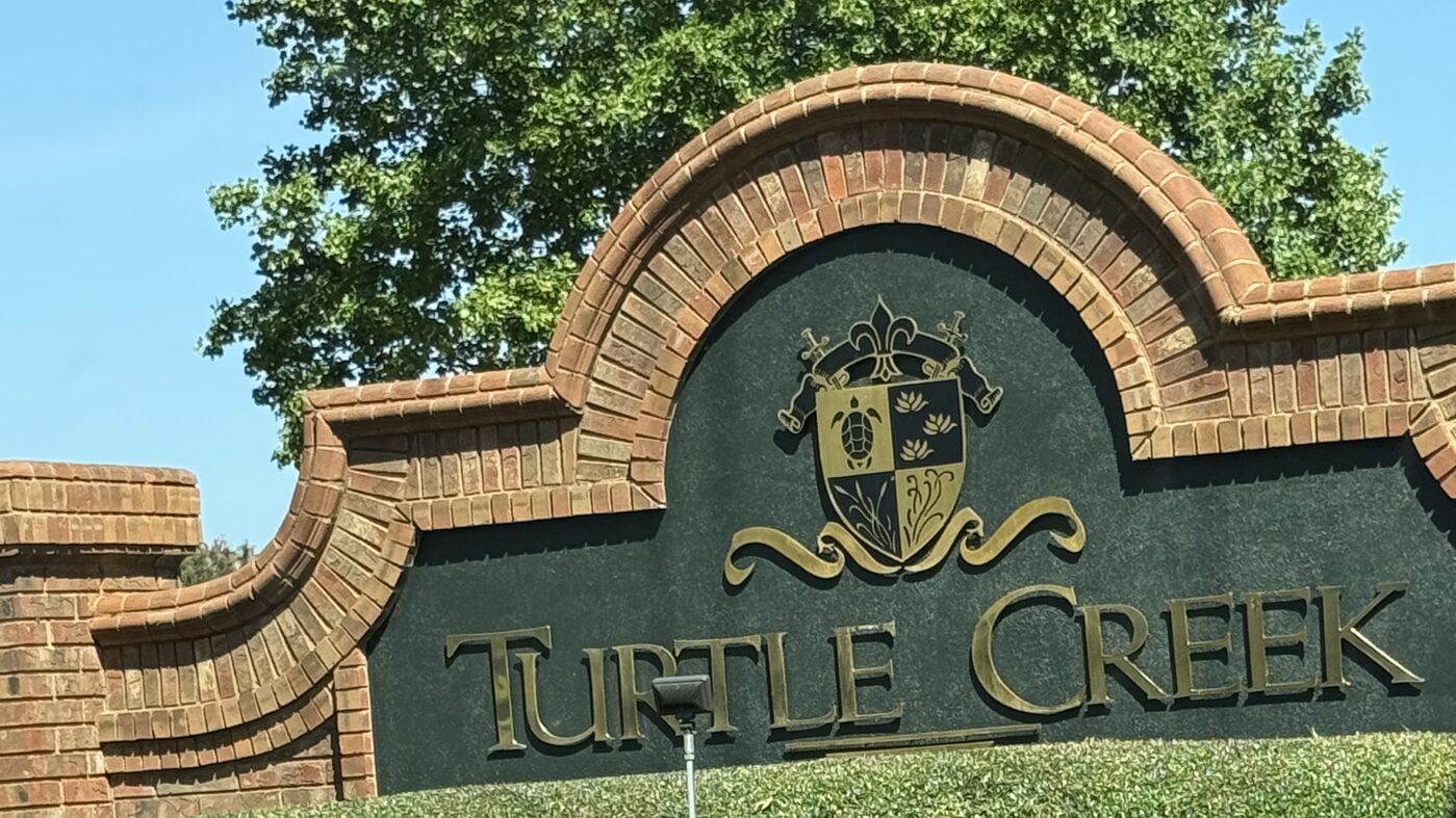 The brick Turtle Creek entrance monument with gold lettering and turtle crest at the neighborhood entrance in Boiling Springs, SC